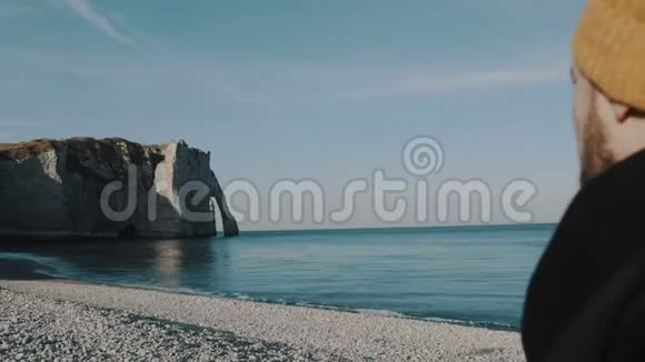 后景愉快兴奋的游客观看史诗般的白色岩石在阳光下的鹅卵石海滩在埃特雷特法国慢动作视频的预览图