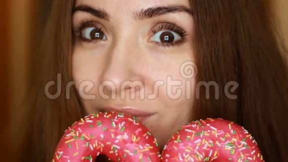 饮食节食贴身女人吃粉红色甜甜圈美味甜蜜甜蜜的牙齿视频的预览图