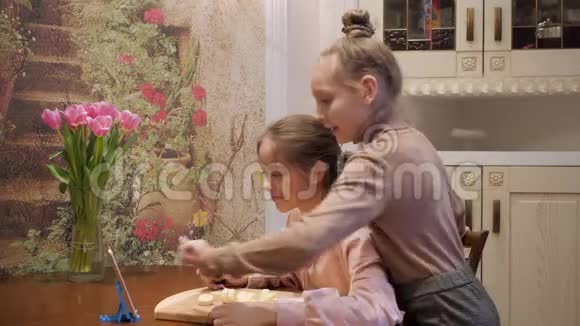 少女在家庭厨房拍摄厨师博客在社交网络上播放烹饪博客的女朋友视频的预览图