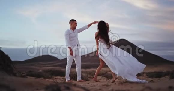 浪漫的一对情侣在美丽的风景中和满是山和田野的人一起跳舞视频的预览图