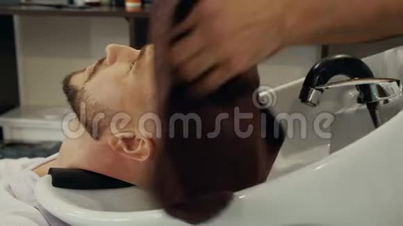 发型师用毛巾擦拭客户头部特写图视频的预览图