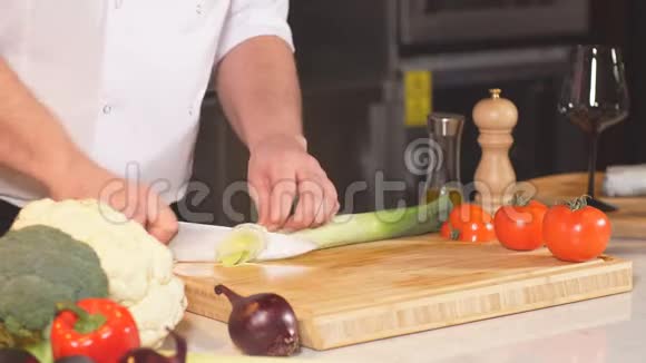 一名厨师的特写熟练地在切割板上切割五颜六色的蔬菜番茄和蘑菇视频的预览图