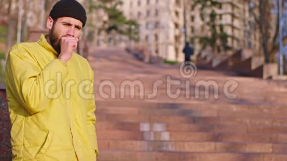 穿黄色夹克的年轻人咳嗽得很厉害一个陌生人给了他一个安全的防护面具视频的预览图
