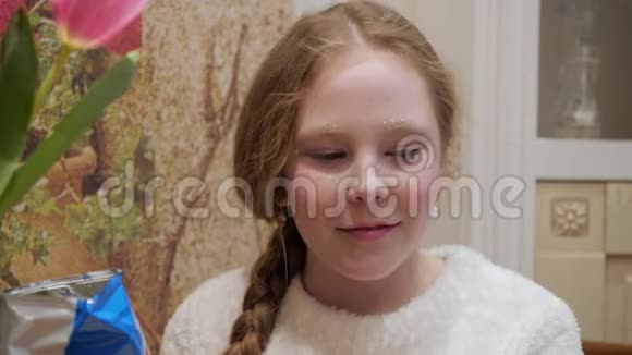 肖像少年女孩在家厨房吃薯片特写脸上雀斑的少女在吃脆片视频的预览图