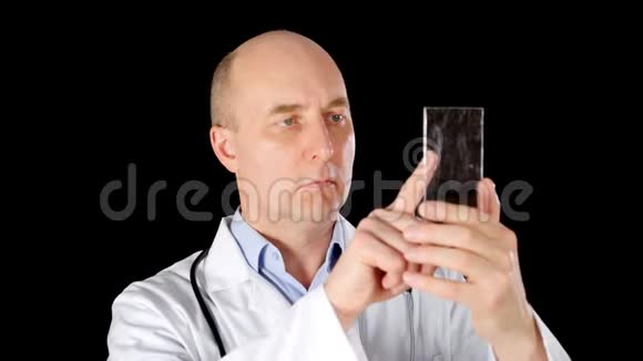严重的男性医生使用透明的数字设备隔离黑色背景视频的预览图