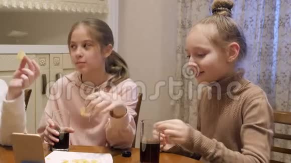 十几岁的女孩在家庭聚会上吃土豆酥喝可乐少女朋友在家玩美食派对视频的预览图