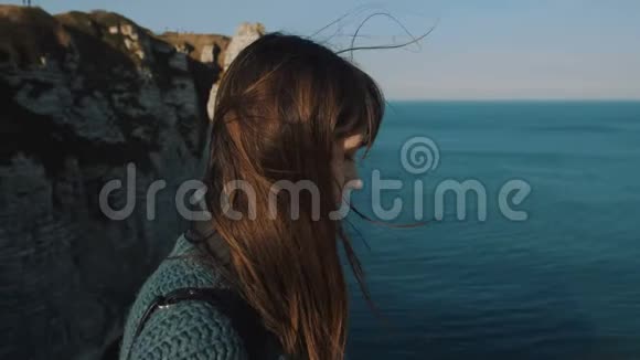后景年轻的黑发旅行者女人看着史诗般的自然风景在埃特雷特头发在风中缓慢的运动视频的预览图