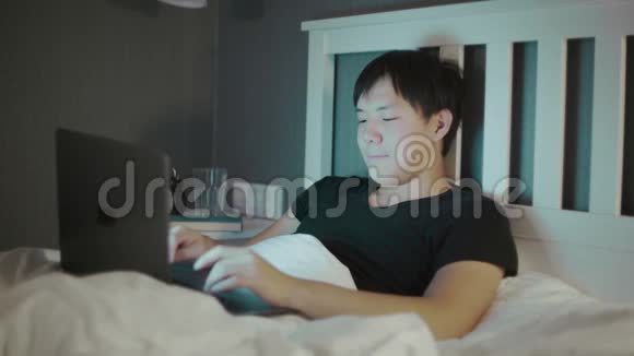 深夜在床上使用笔记本电脑的亚洲年轻人视频的预览图