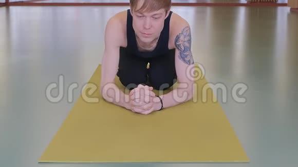 瑜伽课一个年轻人在工作室的黄色地毯上做运动视频的预览图