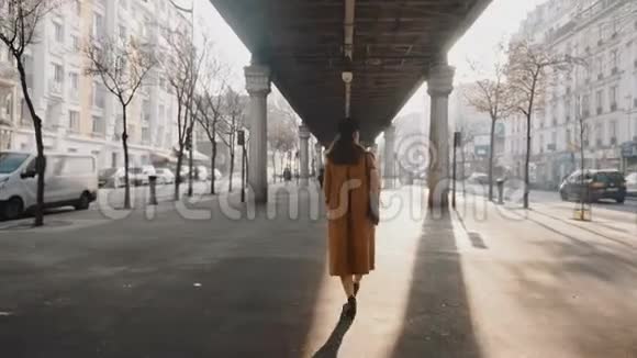 宽镜头镜头跟随时尚美丽的女人沿着巴黎街道在高线地铁立交桥缓慢运动视频的预览图