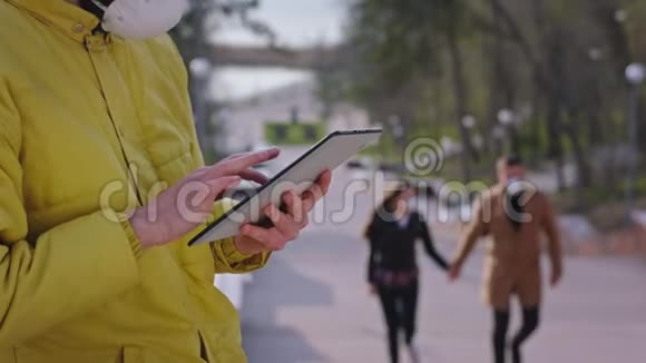 在公园流行的时候一个男人用药片戴着防护面具另一对夫妇在散步视频的预览图