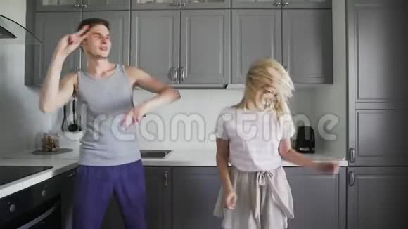 有趣的年轻人在家里的厨房里一起笑一起傻一起跳舞视频的预览图