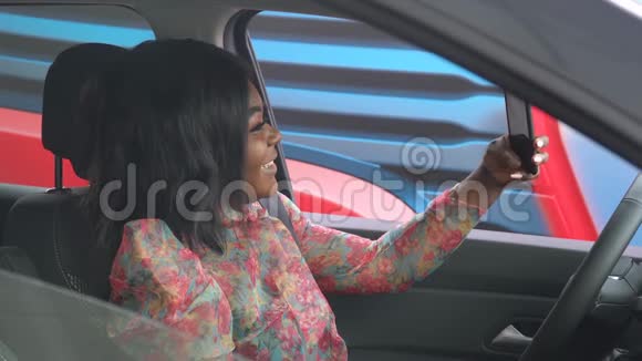一位非洲裔美国妇女坐在一个大型商业论坛的车里自拍视频的预览图