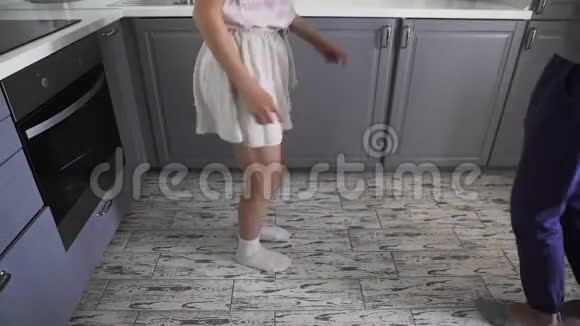 低角度拍摄吸引人的年轻快乐夫妇在家厨房做饭时尽情跳舞视频的预览图