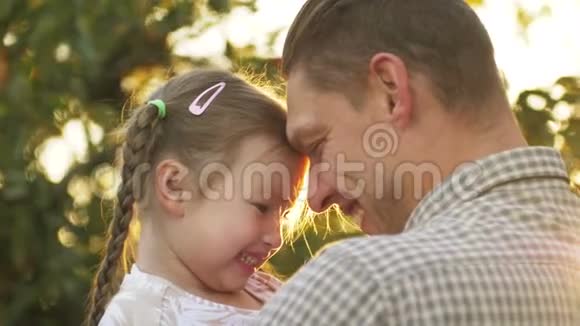 父亲手里拿着小女孩在户外拥抱的肖像爸爸咕哝着和他接吻视频的预览图