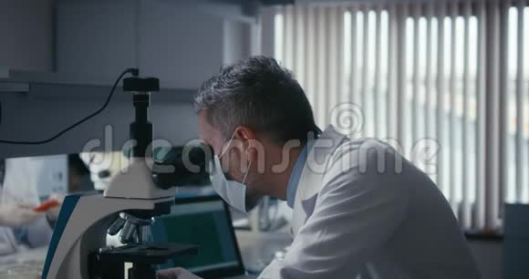 显微镜下研究样品的科学家视频的预览图