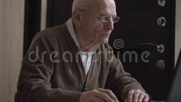 老人坐在无线电脑上退休后工作视频的预览图
