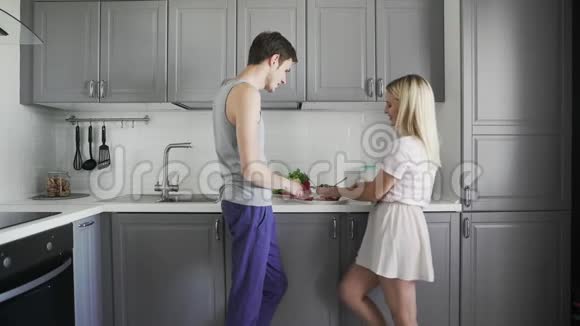 爱的夫妻在厨房里聊天切西红柿一起准备沙拉视频的预览图
