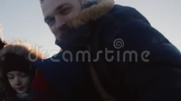 快乐微笑的白种人四口之家在强烈的寒风下拍摄了一张自拍冬季的慢动作视频的预览图