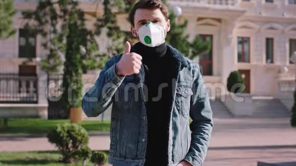 一名男子在街中央的摄像头前戴着冠状病毒监测器防护面罩视频的预览图