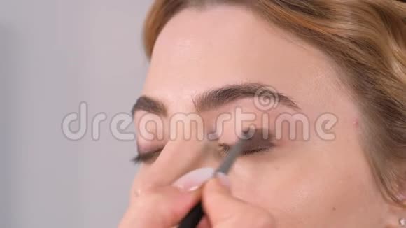 化妆给了少女表情的眼神用化妆铅笔划眼轮廓视频的预览图