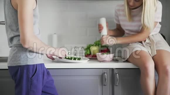 爱的夫妇一起切蔬菜在沙拉中加入香料午餐在厨房视频的预览图