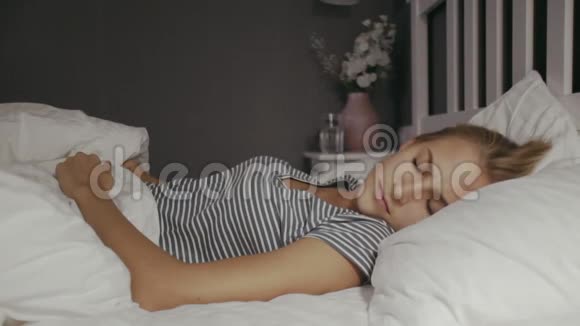 年轻的女人晚上躺在床上美丽的金发女郎女人有个噩梦视频的预览图