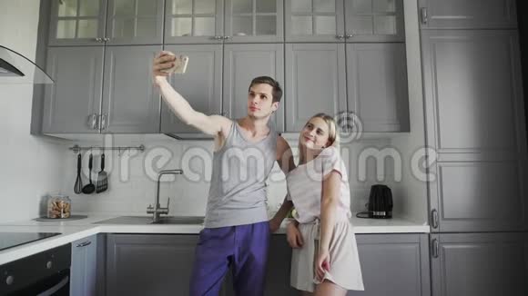 年轻夫妇早上在厨房里微笑摆姿势和自拍视频的预览图
