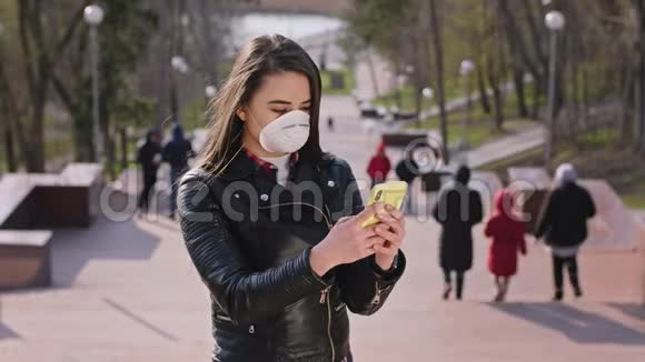 一位新的冠状病毒概念女士带着手机在公园旁边打电话她带着一个保护装置视频的预览图