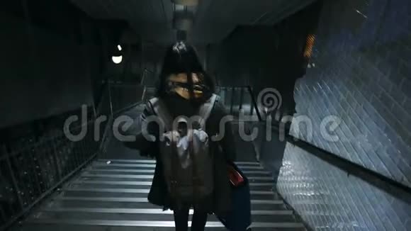 镜头跟随年轻的旅游妇女走下楼梯进入地铁交叉口背包和手提箱慢动作视频的预览图