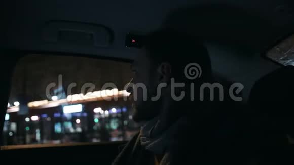 特写年轻英俊体贴的商人从窗外看着夜城出租车后座的慢动作视频的预览图