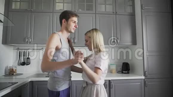 有魅力的年轻快乐的一对夫妇在家厨房做饭时跳着浪漫的舞蹈视频的预览图
