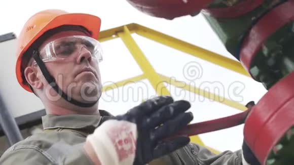油田技术工人监督原油生产现场的缓慢运动工业油泵千斤顶工作视频的预览图