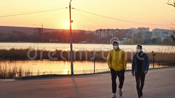 在公园的日落时分长相英俊的男人走在镜头前他们戴着防护面具视频的预览图