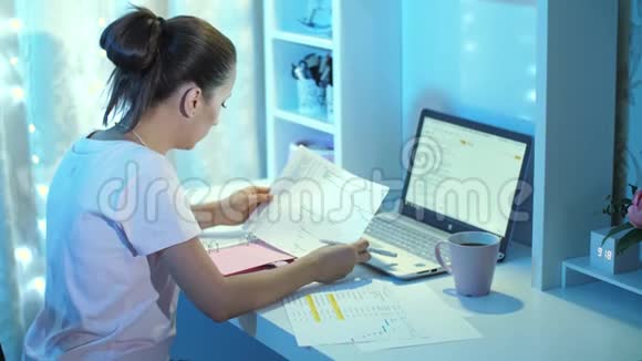 女人晚上在笔记本电脑上工作视频的预览图