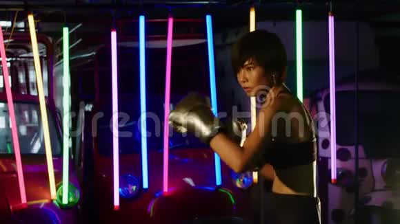 女子拳击手练习拳击霓虹灯体育馆视频的预览图