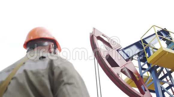 原油生产现场监督抽油机的油工剪影工业油泵千斤顶工作视频的预览图