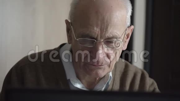 老秃头坐在电脑旁寻找健康的建议视频的预览图