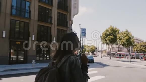 令人惊叹的慢镜头快乐放松的年轻旅游妇女与背包享受阳光旧金山街头散步视频的预览图