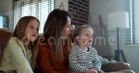 快乐的年轻白种人妈妈和孩子一起看动画片家人一起在家分享快乐时光视频的预览图