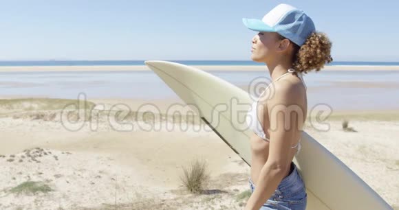微笑运动的女人拥抱冲浪板视频的预览图
