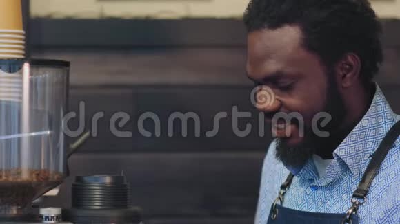 特写非洲咖啡师用现代机器研磨咖啡豆视频的预览图