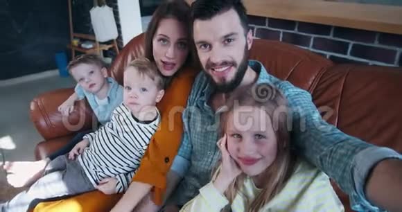 幸福家庭自拍在一起年轻的白种人爸爸妈妈和三个孩子在家慢动作拍照视频的预览图