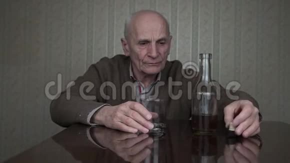 老人用颤抖的手拿着杯子喝干邑白兰地视频的预览图