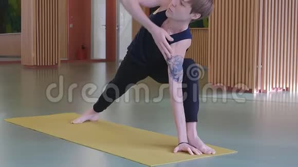 一个年轻英俊的高加索男人正在做瑜伽在黄色的工作室里做伸展和柔韧性练习吗视频的预览图