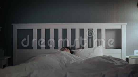 懒惰的亚洲年轻人在家里的床上醒来视频的预览图