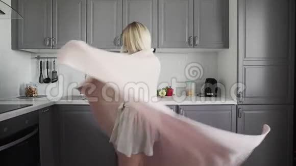 快乐的女孩在格子里旋转早上在厨房里微笑视频的预览图