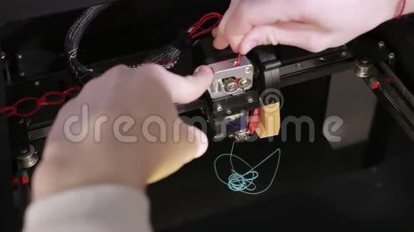 3D技术两个人用手把塑料灰线塞进打印机的针中视频的预览图