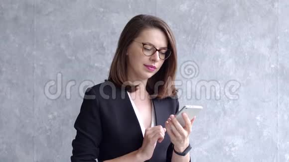 一位积极的女商人在灰色背景下打电话的肖像视频的预览图