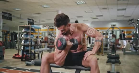 在一个现代化的健身房里肌肉发达身材英俊的男人锻炼身体以获得更健康和强壮的二头肌锻炼视频的预览图
